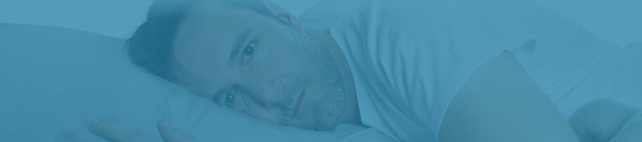 Man lying in bed having trouble sleeping